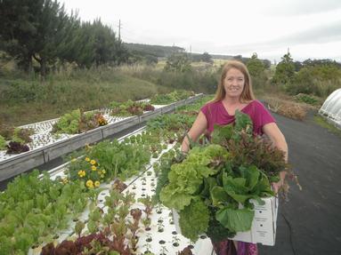 Susanne Friend holding armfuls of fresh produce from FriendlyAquaponics